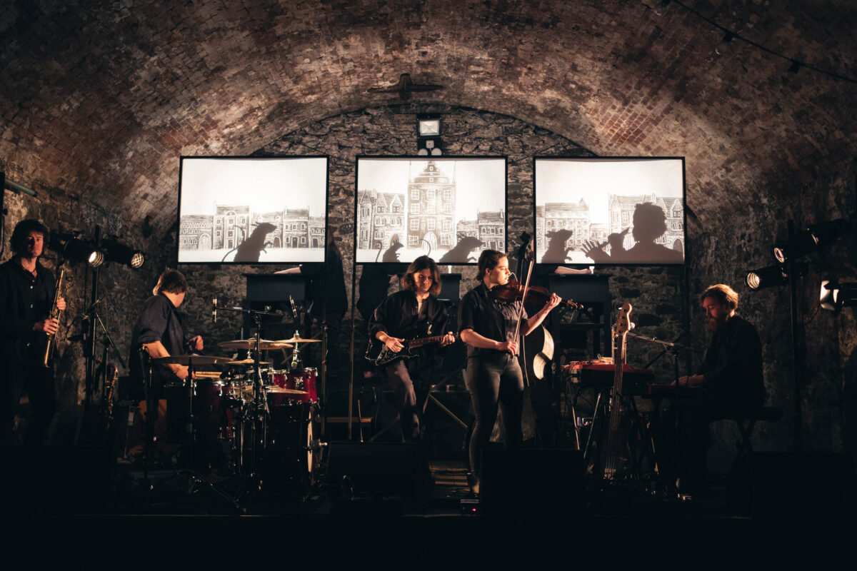 Band performing in tunnel with images