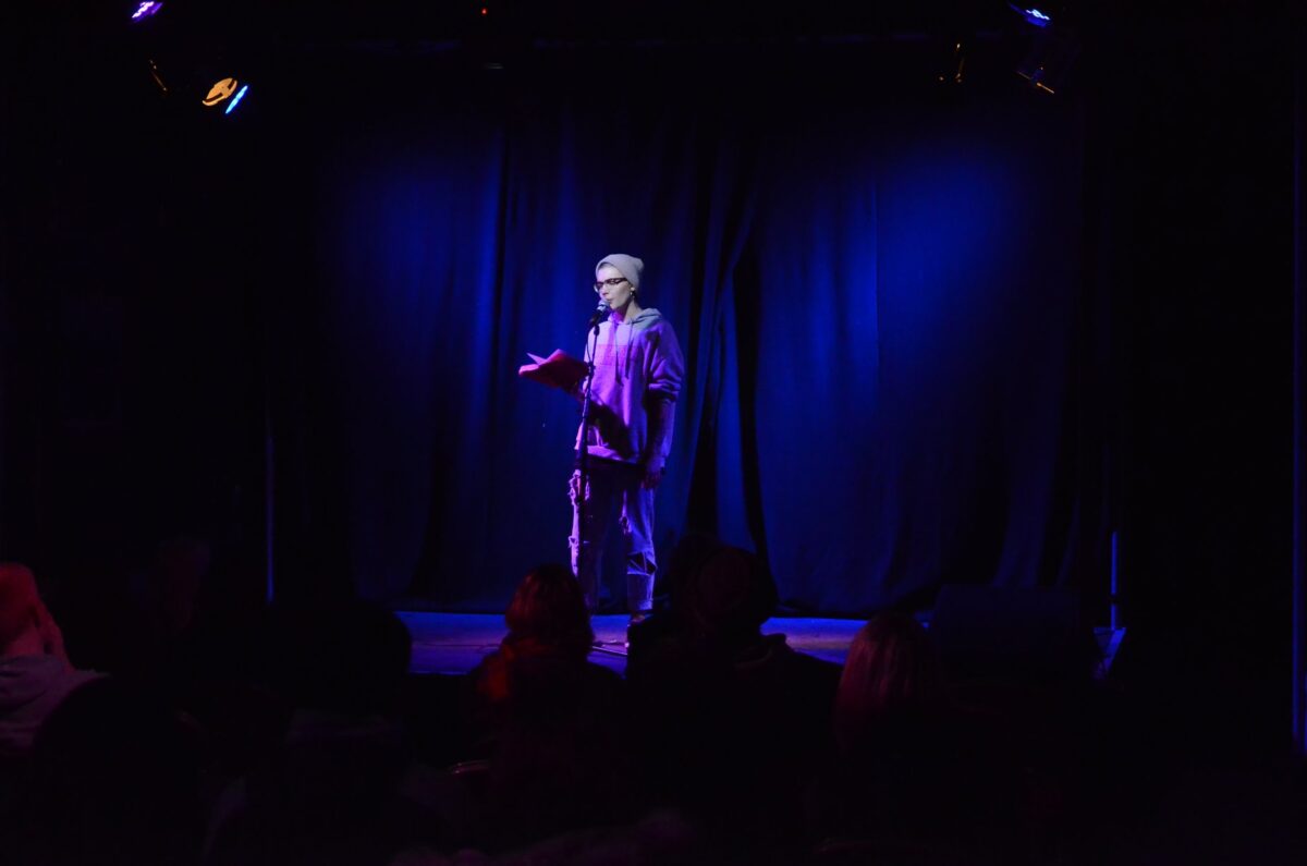 comedian on stage in a dark room