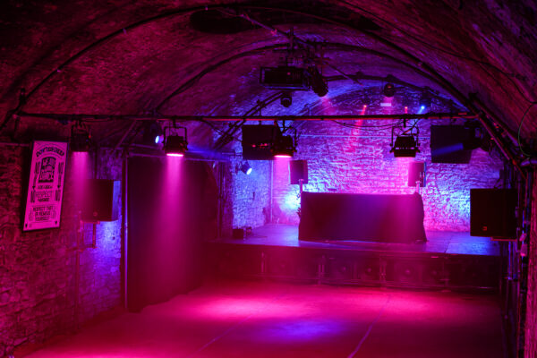 Tunnel two stage lit up with purple and pink lighting.