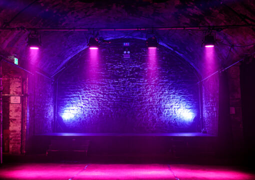 A straight on photo of the Tunnel 2 stage lit up with pink lighting.