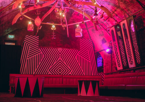 A photo of the seating a decor in tunnel 3 lit up with red lighting.