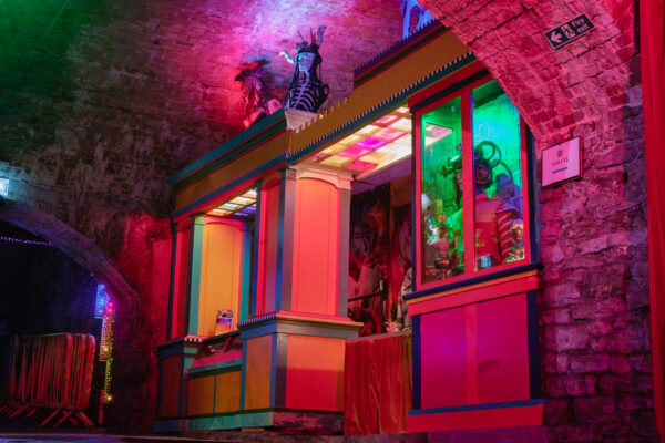 A photo of the Loco Klub box office lit up with colourful lights.